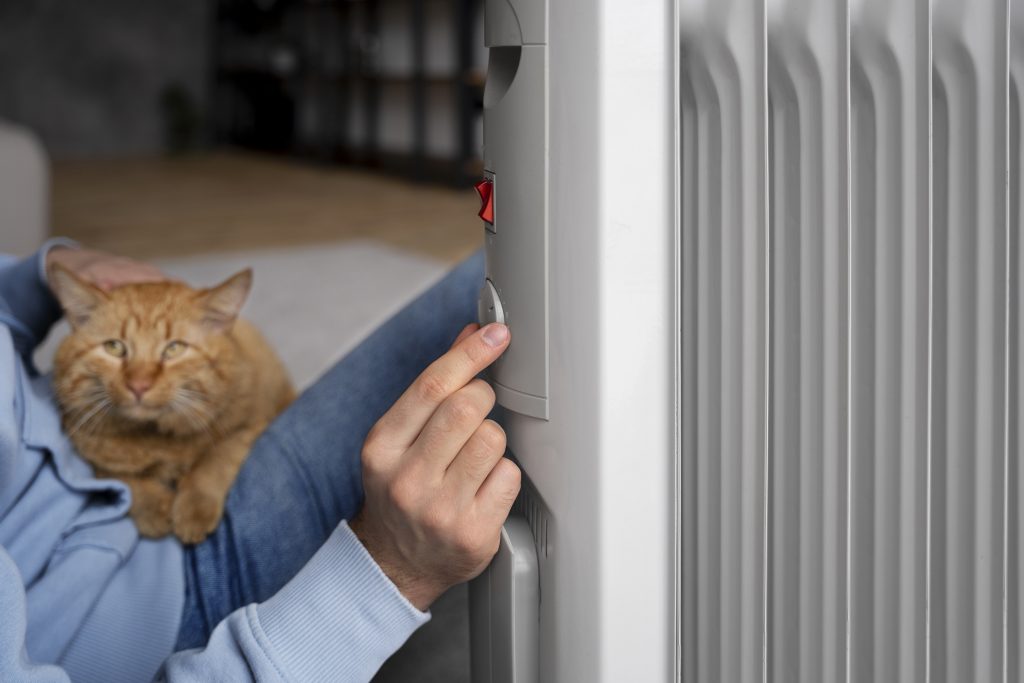 owner-holding-cat-turning-up-heat Équilibrage de radiateurs haute et basse température