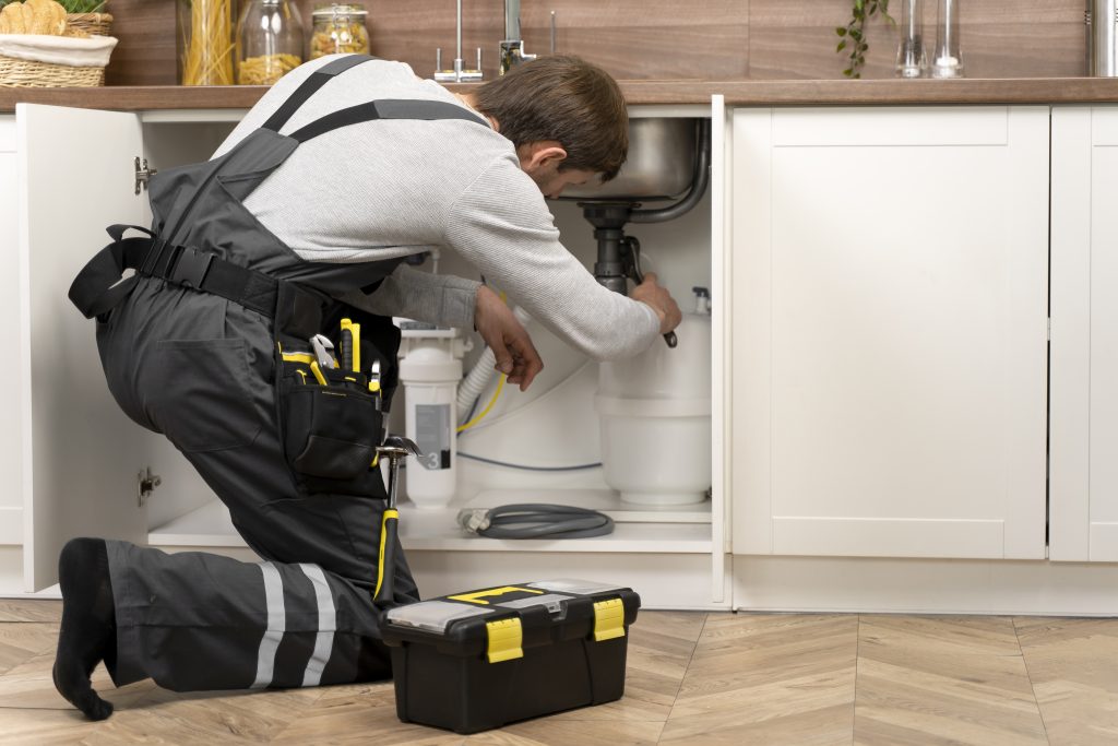 Technicien MINUTENERGY intervenant sur une fuite ou réparation de plomberie