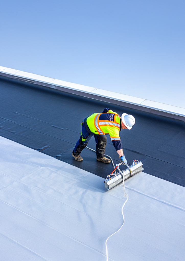 Technicien posant une membrane d’étanchéité toiture-terrasse en Auvergne-Rhône-Alpes